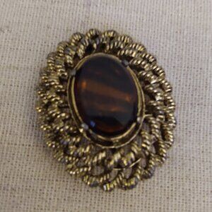 Gold tone oval brooch with large brown center stone. Marked Gerry's